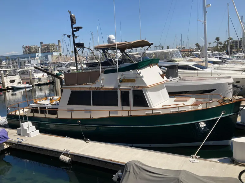 Slide: The Image of 1985 Grand Banks 42 Classic yacht docked at a marina, surrounded by other boats. - 4