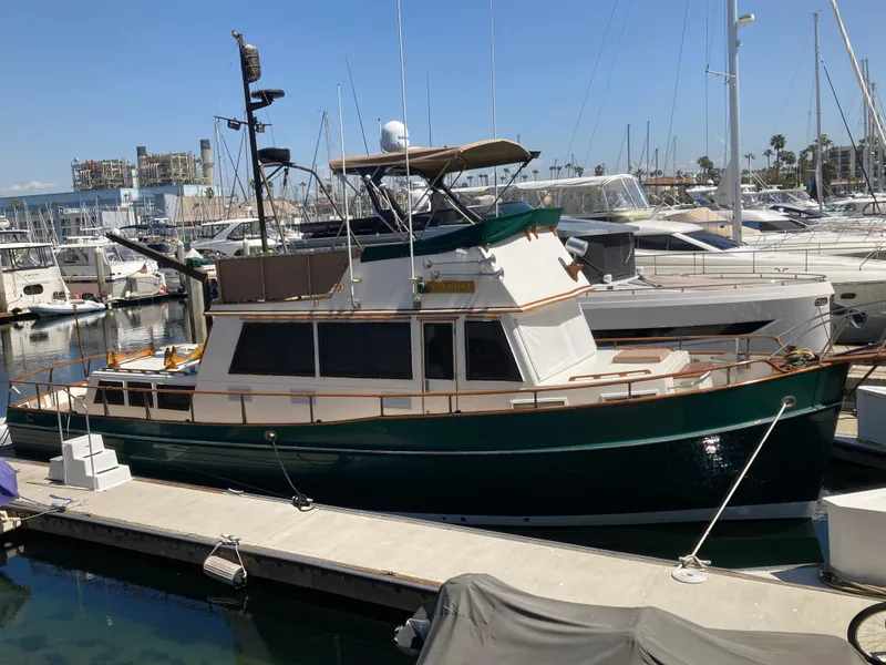 Slide: The Image of 1985 Grand Banks 42 Classic yacht docked at a marina, surrounded by other boats. - 5