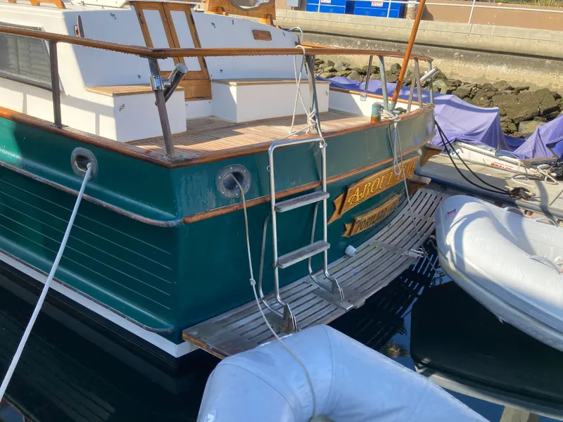 Slide: The Image of 1985 Grand Banks 42 Classic yacht docked, featuring a green hull and wooden deck. - 6