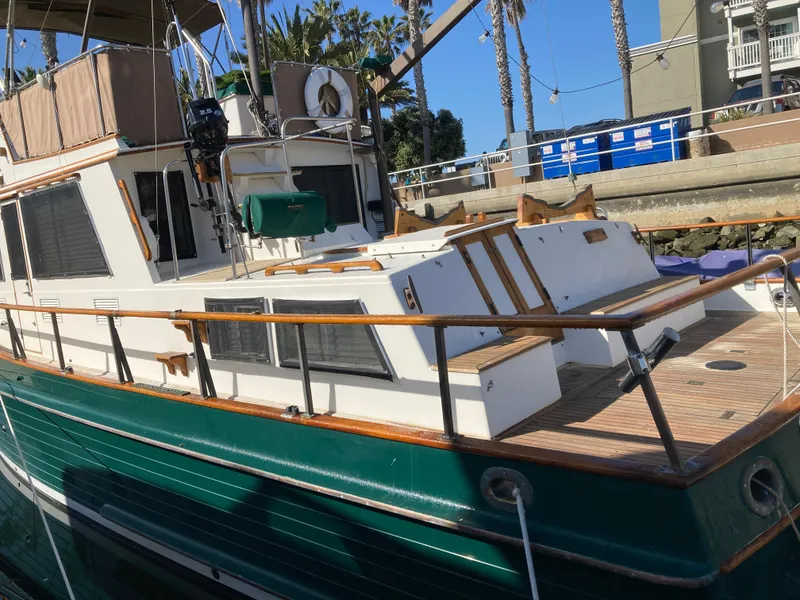 Slide: The Image of 1985 Grand Banks 42 Classic yacht docked, featuring wooden railings and a green hull. - 8