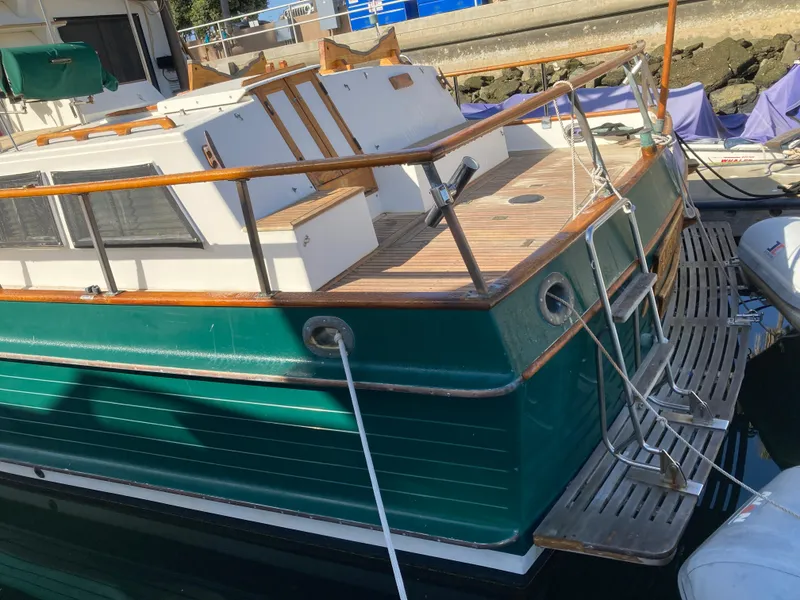 Slide: The Image of 1985 Grand Banks 42 Classic yacht with green hull, docked at marina. - 9