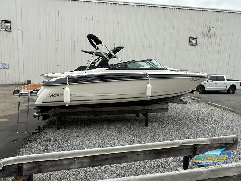 Slide: The Image of 2014 Monterey 244FS boat on display in a gravel lot near a warehouse. - 6