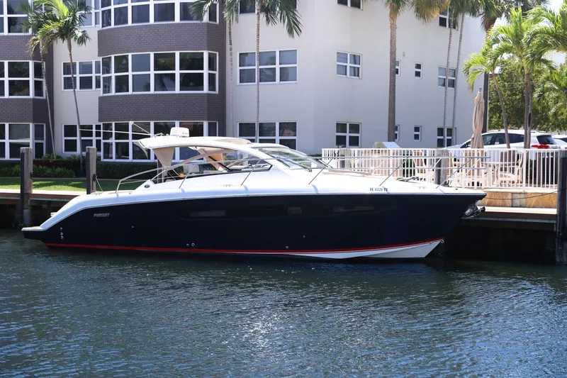 The Image of 2016 Pursuit SC 365i yacht docked near waterfront apartments. - 0