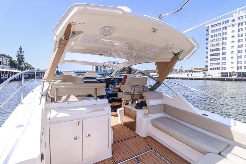 Slide: The Image of 2016 Pursuit SC 365i yacht interior with seating, helm, and waterfront view. - 10