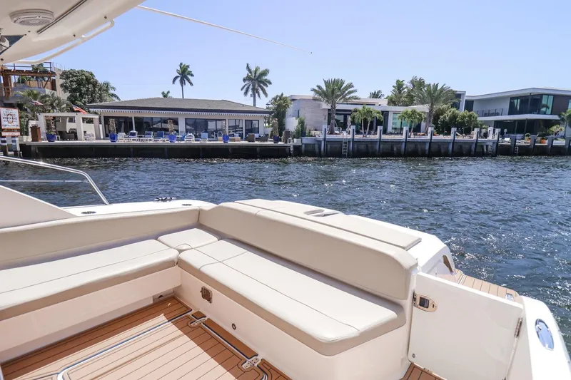 Slide: The Image of Luxury 2016 Pursuit SC 365i yacht with spacious seating, docked near waterfront homes. - 12