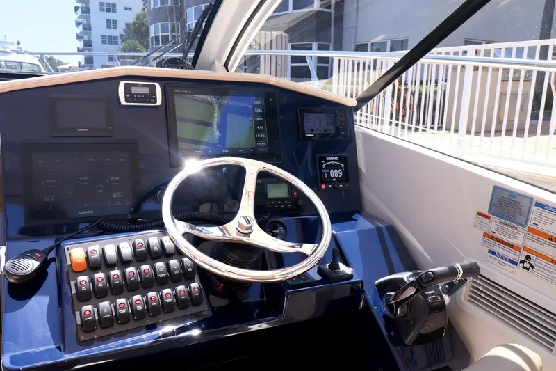 Slide: The Image of 2016 Pursuit SC 365i helm with steering wheel, control panel, and navigation screens. - 19