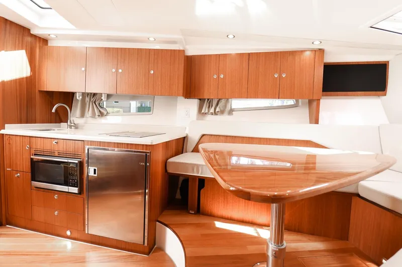Slide: The Image of 2016 Pursuit SC 365i yacht interior with modern kitchen and dining area. - 23