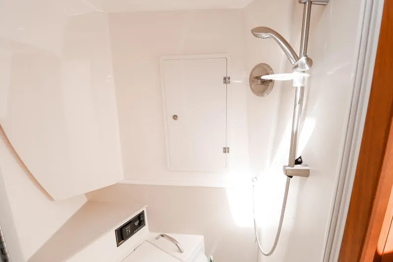 Slide: The Image of 2016 Pursuit SC 365i boat bathroom with shower and storage compartment. - 26