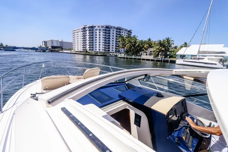 Slide: The Image of 2016 Pursuit SC 365i yacht cruising near waterfront buildings and palm trees. - 6