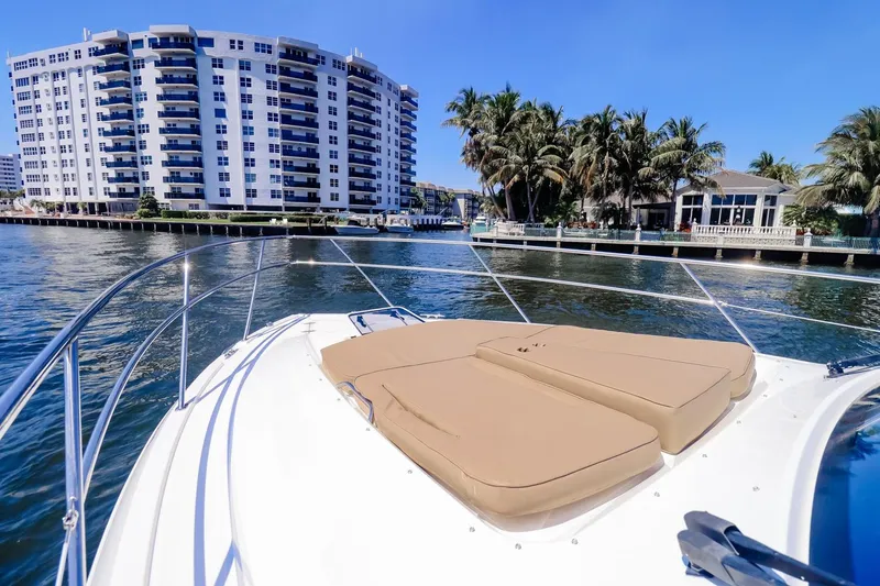 Slide: The Image of 2016 Pursuit SC 365i boat with sun pads, cruising near waterfront buildings and palm trees. - 8
