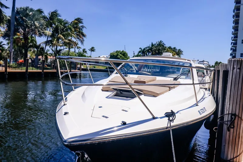Slide: The Image of 2016 Pursuit SC 365i boat docked by palm trees and waterway. - 9