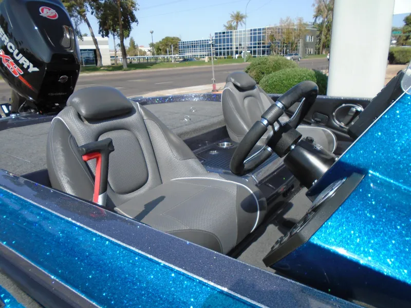 Slide: The Image of 2018 Ranger Z518 Comanche boat interior with gray seats and steering wheel, parked outdoors. - 13