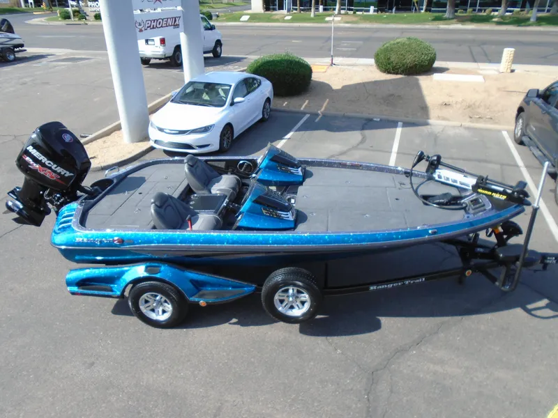 Slide: The Image of 2018 Ranger Z518 Comanche boat in parking lot, blue exterior, with Mercury engine. - 3