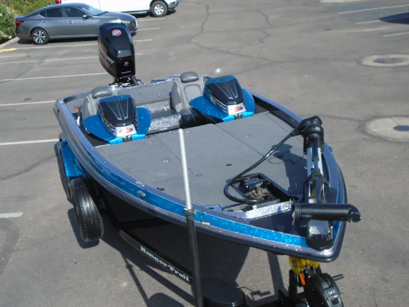 Slide: The Image of 2018 Ranger Z518 Comanche boat in parking lot, blue exterior, dual seats, motor visible. - 4