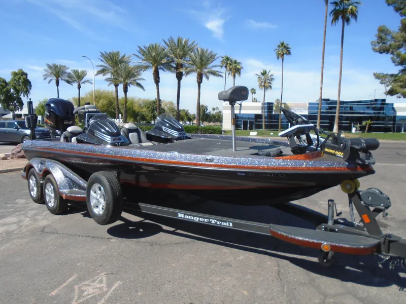 Slide: The Image of 2015 Ranger Z521 Comanche boat on trailer, parked outdoors with palm trees in the background. - 2