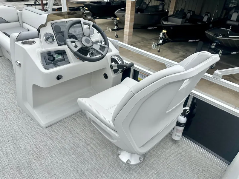 Slide: The Image of 2025 Avalon 23' Venture Quad Lounger boat interior with steering console and captain's chair. - 14