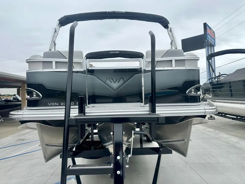 Slide: The Image of 2025 Avalon 23' Venture Quad Lounger with 150HP Mercury, displayed on a trailer. - 2