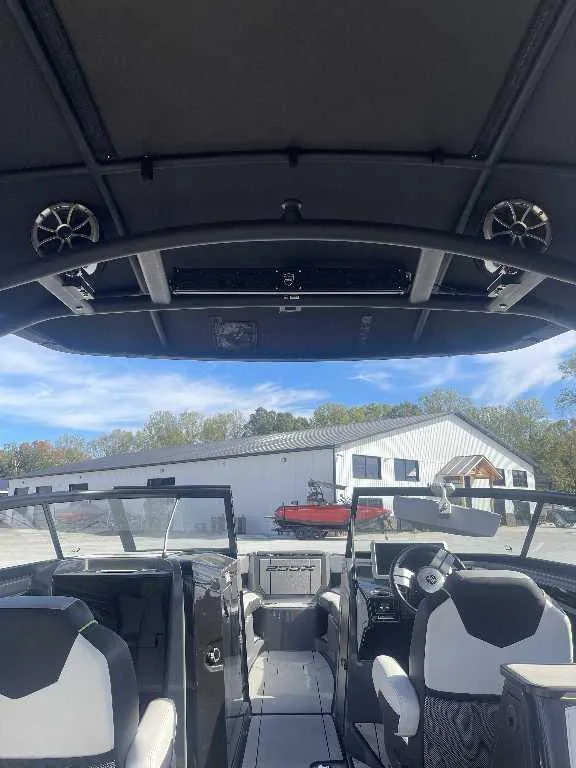 Slide: The Image of Interior view of 2021 Yamaha Boats 255X, showcasing seating and dashboard under a clear sky. - 10