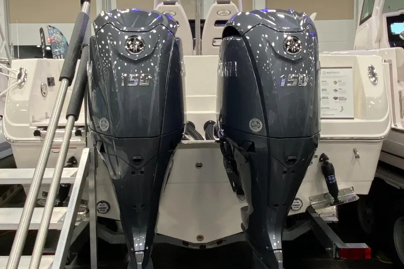 Slide: The Image of 2024 Sailfish 242 CC boat with dual Yamaha 150 engines displayed at a boat show. - 12
