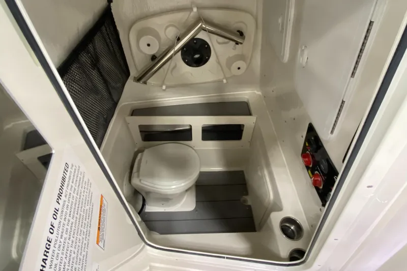 Slide: The Image of 2024 Sailfish 242 CC boat interior with compact marine toilet and storage features. - 6