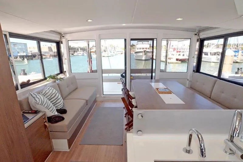 Slide: The Image of Modern Bali 4.6 yacht interior with spacious seating, dining area, and marina view, 2022 model. - 2