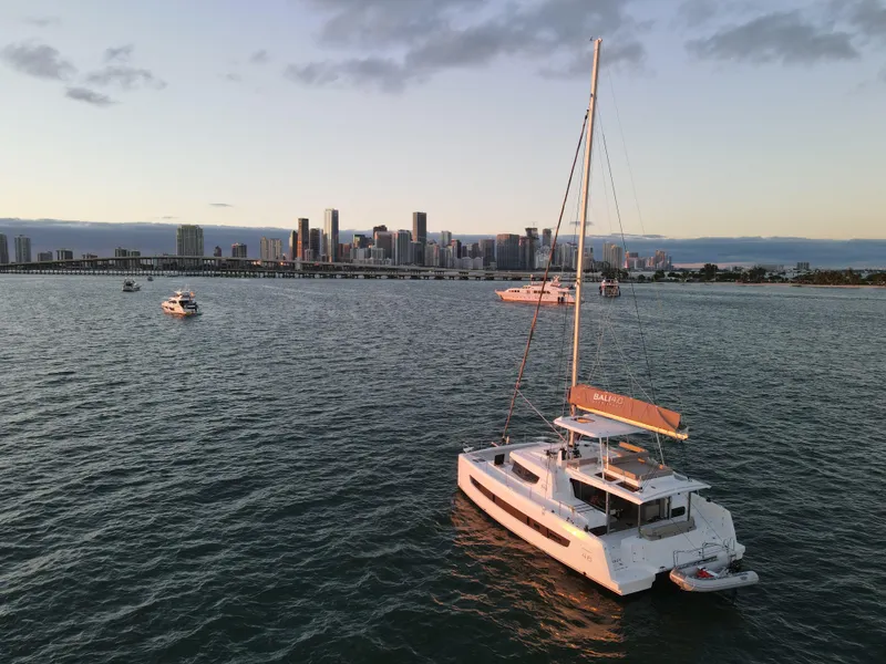 Slide: The Image of Sailboat Bali 4.6 (2022) on water with city skyline in background at sunset. - 44