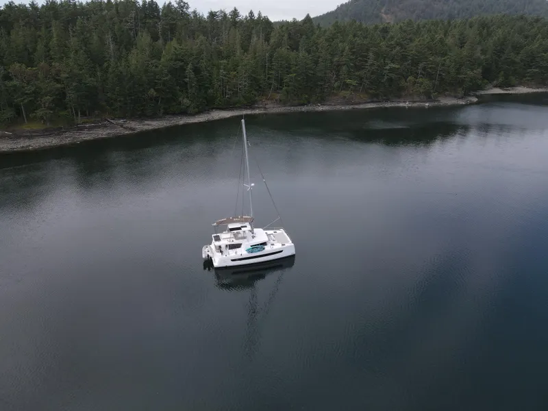 Slide: The Image of Aerial view of 2022 Bali 4.6 catamaran anchored in serene forested bay. - 49