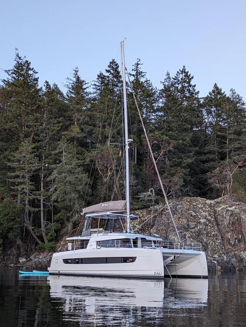 Slide: The Image of 2022 Bali 4.6 catamaran anchored near forested shoreline. - 63