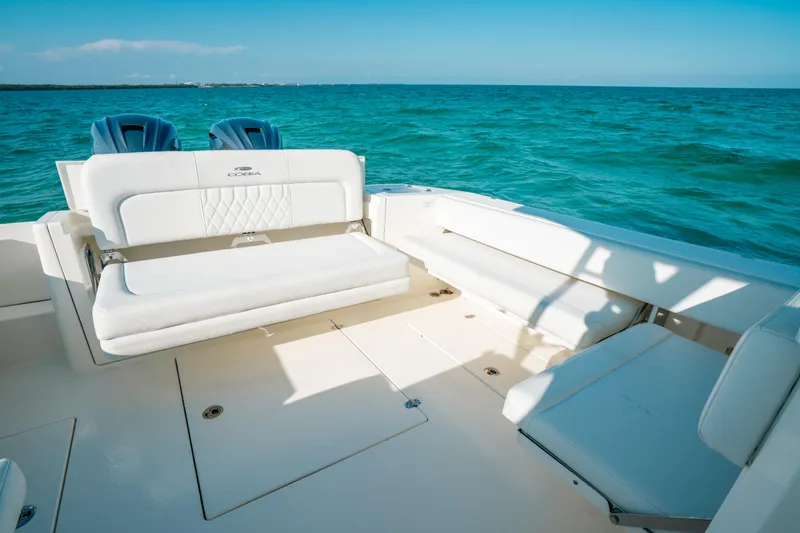 Slide: The Image of 2024 Cobia 330 Dual Console boat interior with white seating, ocean view. - 10