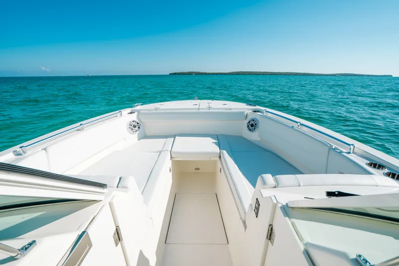 Slide: The Image of 2024 Cobia 330 Dual Console boat on clear blue ocean water. - 12