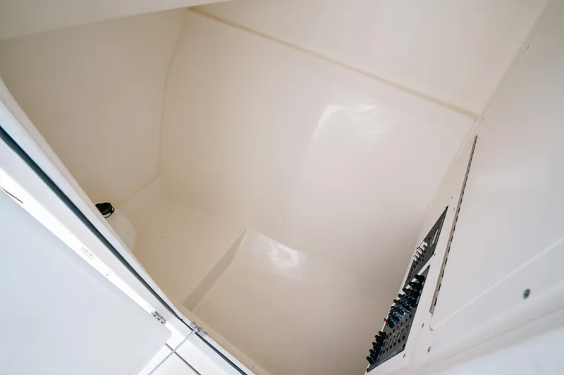 Slide: The Image of 2024 Cobia 330 Dual Console interior compartment, featuring sleek white surfaces and control panel. - 17