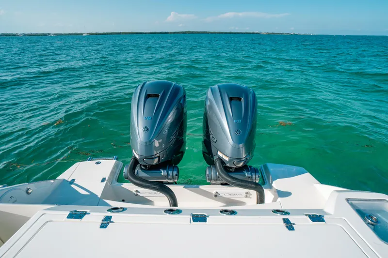 Slide: The Image of 2024 Cobia 330 Dual Console boat with twin engines on open water. - 20