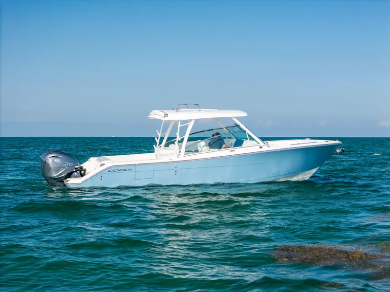 Slide: The Image of 2024 Cobia 330 Dual Console boat cruising on open water. - 21