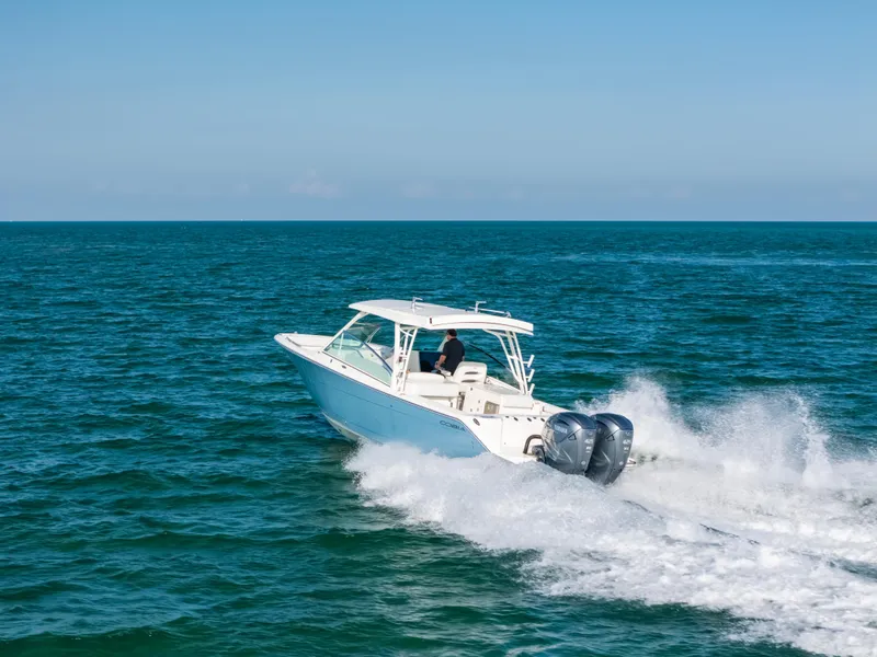 Slide: The Image of 2024 Cobia 330 Dual Console boat cruising on open ocean waters. - 28