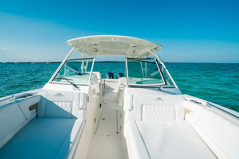 Slide: The Image of 2024 Cobia 330 Dual Console boat on clear blue ocean water. - 33