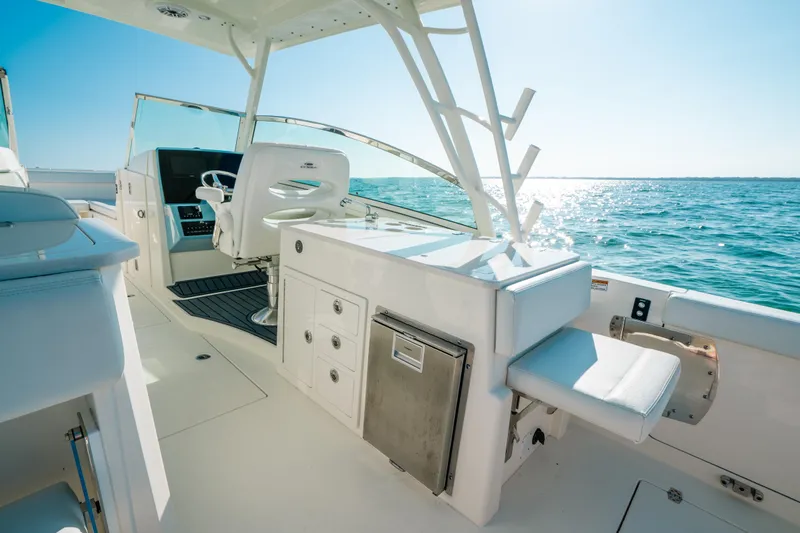 Slide: The Image of 2024 Cobia 330 Dual Console boat interior with ocean view, featuring helm and seating area. - 4