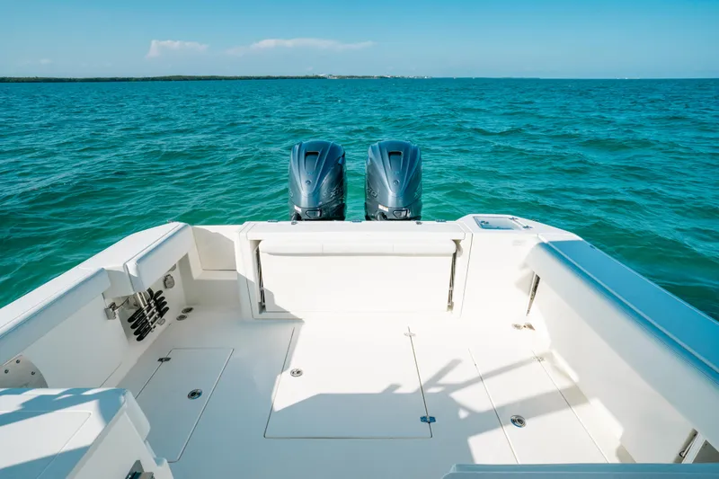 Slide: The Image of 2024 Cobia 330 Dual Console boat on open sea with twin engines. - 9