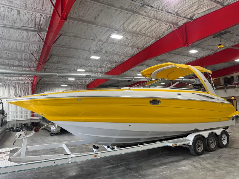 Slide: The Image of 2007 Crownline 320LS boat in vibrant yellow, parked indoors on a trailer. - 3