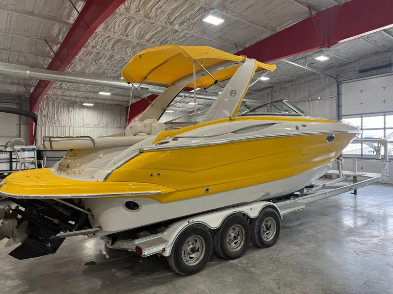 Slide: The Image of 2007 Crownline 320LS boat in a warehouse, vibrant yellow exterior, on a triple-axle trailer. - 5