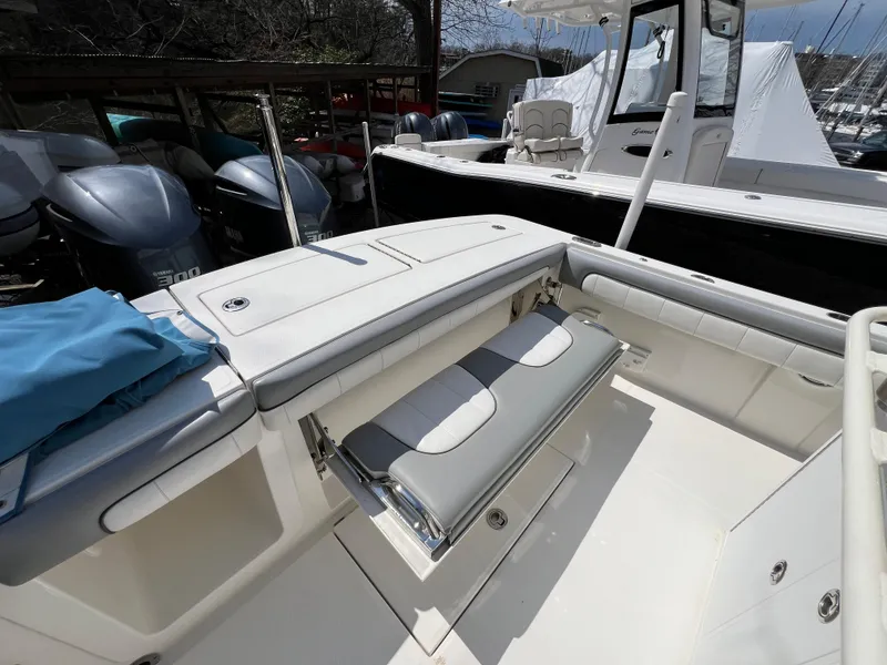 Slide: The Image of 2019 Regulator 28 boat interior with seating and storage, featuring Yamaha engines in the background. - 11
