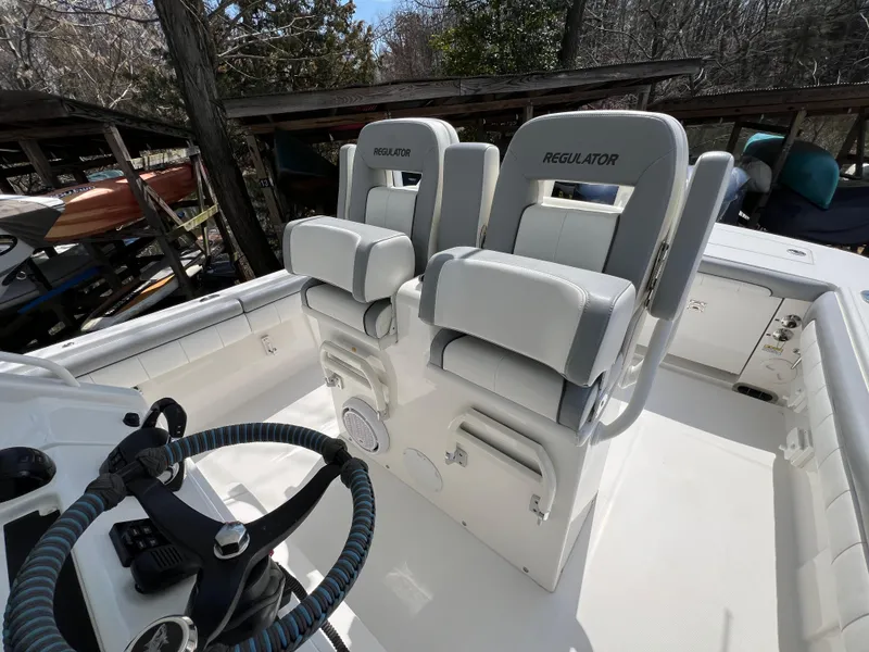 Slide: The Image of 2019 Regulator 28 boat interior with dual captain's chairs and steering wheel. - 20