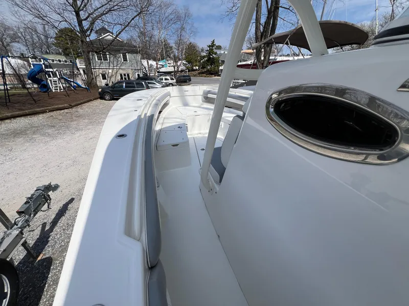 Slide: The Image of 2019 Regulator 28 boat on land, showcasing sleek white design and spacious deck. - 22
