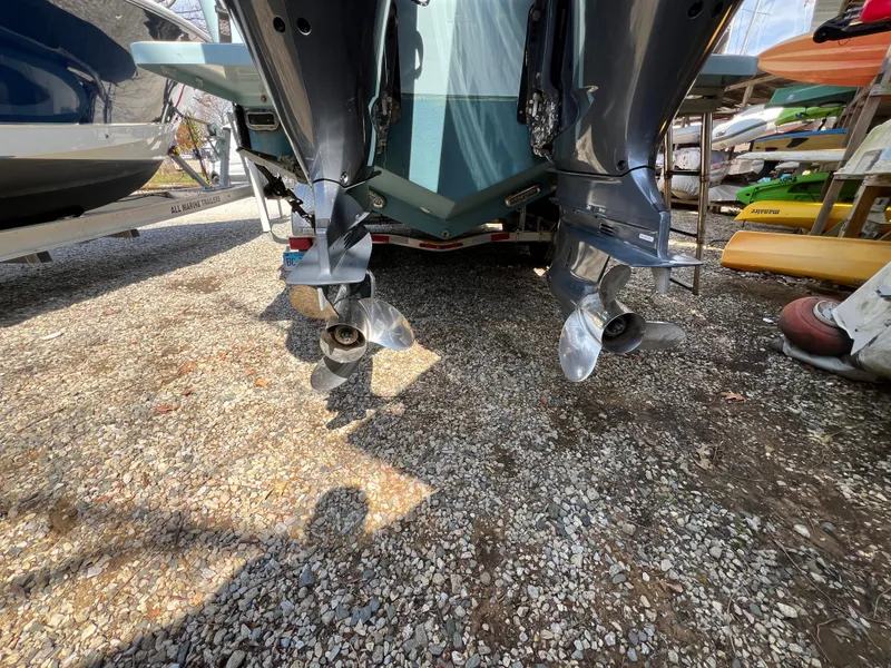 Slide: The Image of 2019 Regulator 28 boat with dual outboard motors on gravel surface. - 3