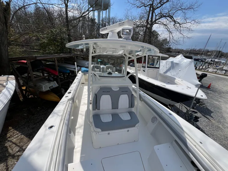 Slide: The Image of 2019 Regulator 28 boat with Garmin equipment, docked near trees and other boats. - 30