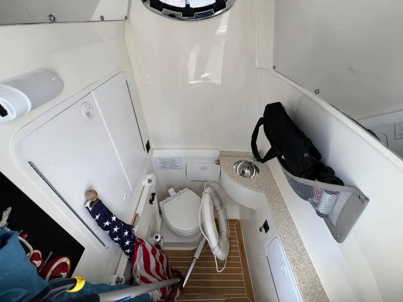 Slide: The Image of 2019 Regulator 28 boat interior with toilet, sink, and storage area. - 38