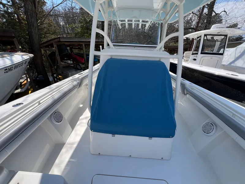 Slide: The Image of 2019 Regulator 28 boat interior with blue seat cover, docked outdoors. - 6