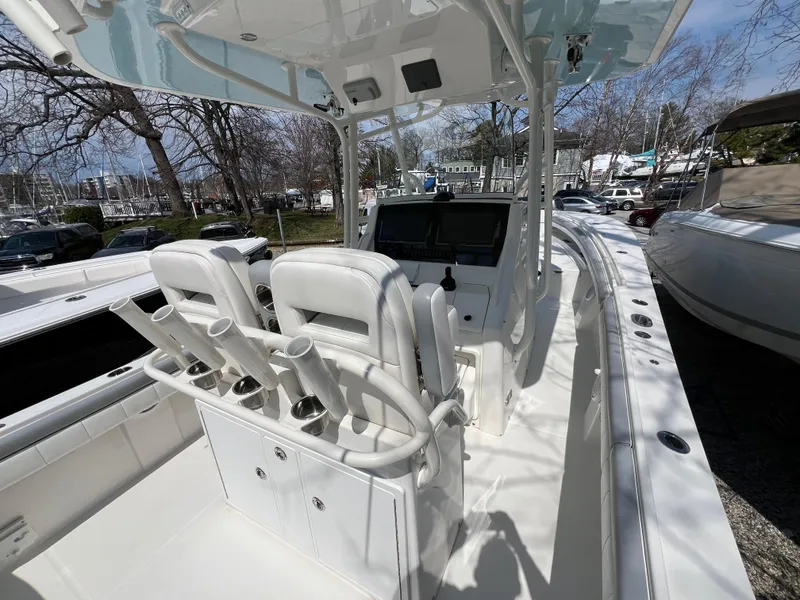 Slide: The Image of 2019 Regulator 28 boat interior with helm, seating, and rod holders, docked outdoors. - 7
