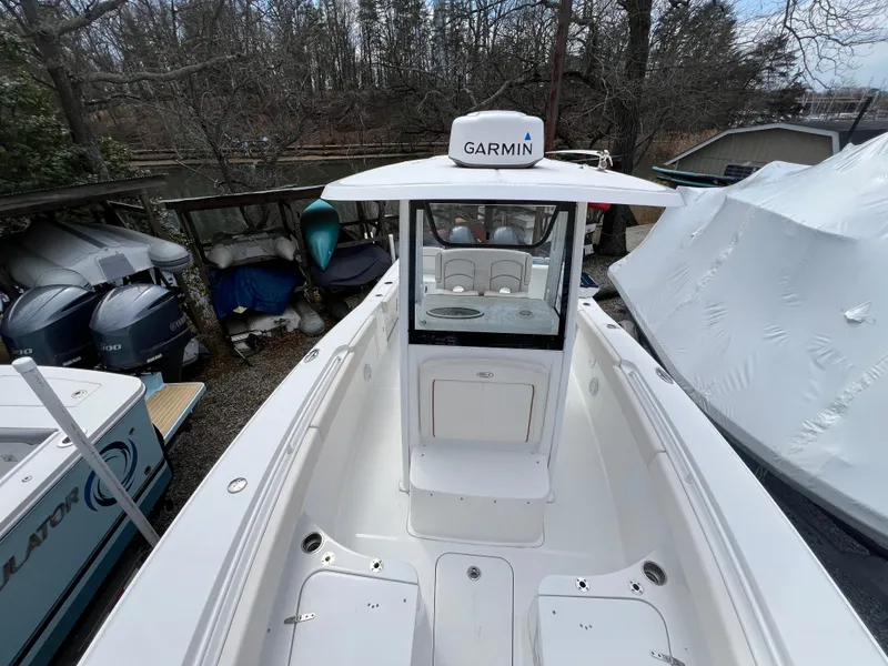 Slide: The Image of 2020 Sea Hunt Gamefish 27 Forward Seating boat with Garmin equipment, docked outdoors. - 27