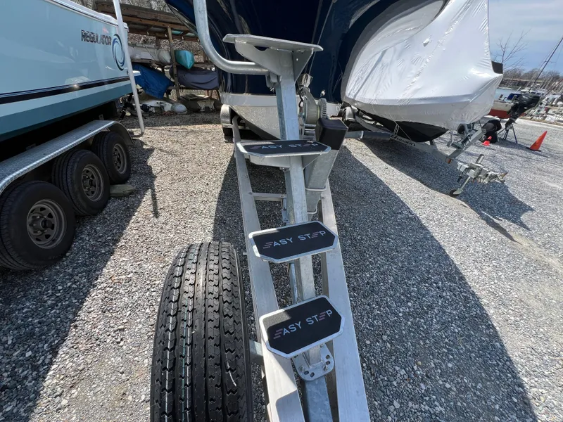 Slide: The Image of 2020 Sea Hunt Gamefish 27 boat on trailer with "Easy Step" ladder, gravel lot. - 35