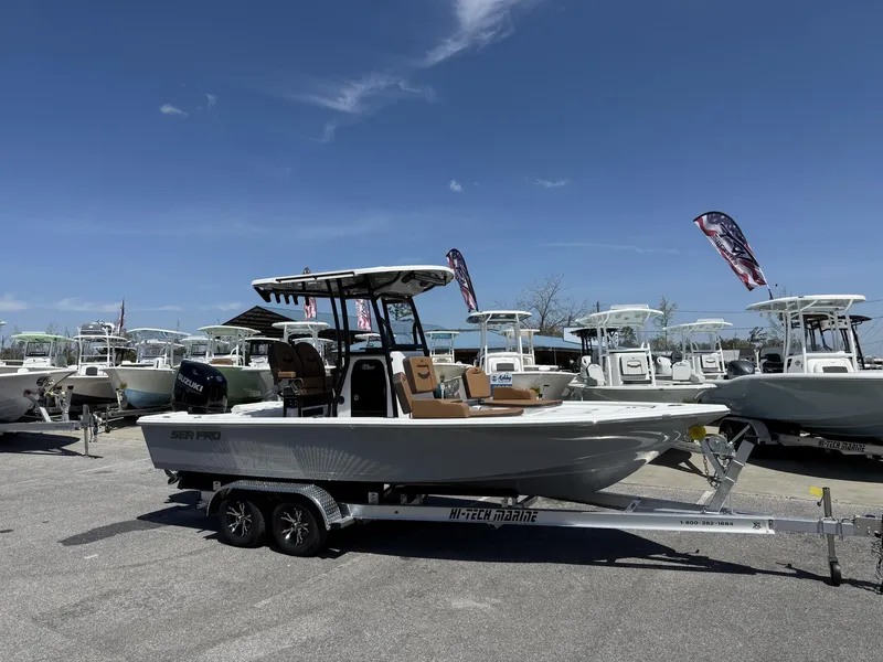 Slide: The Image of 2025 Sea Pro 230 Bay boat on trailer under clear blue sky. - 2